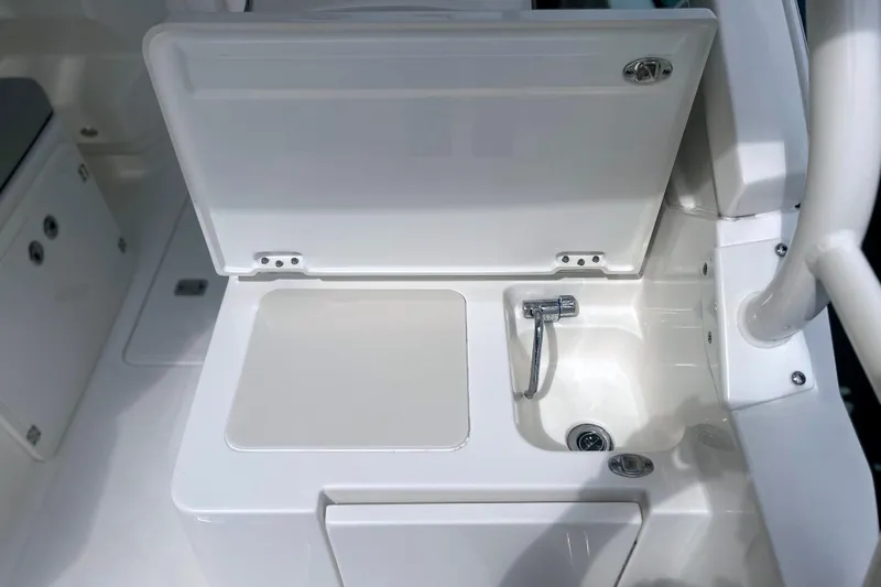 Slide: The Image of 2023 Pursuit DC 266 Dual Console boat sink and storage compartment. - 16