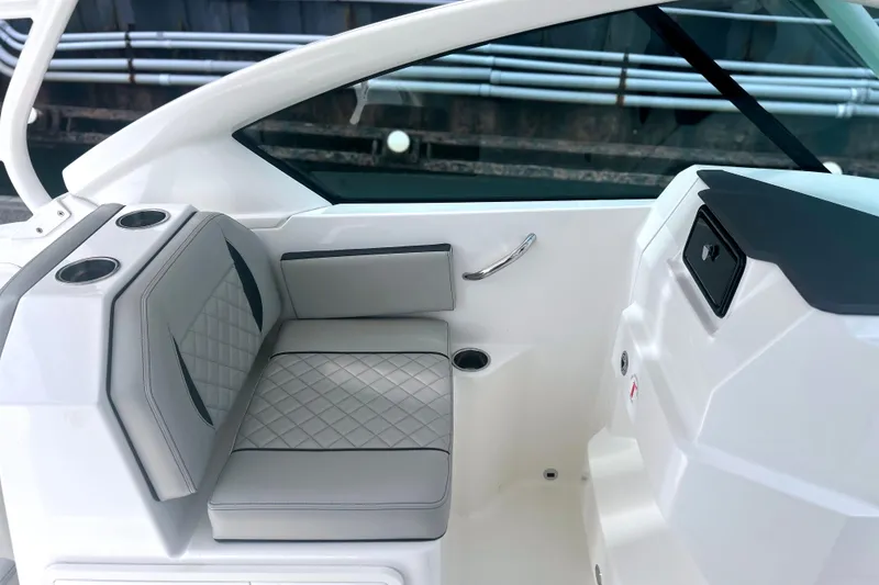 Slide: The Image of 2023 Pursuit DC 266 Dual Console boat interior with cushioned seating and cup holders. - 17