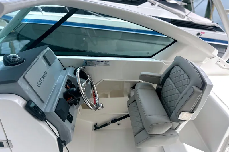 Slide: The Image of 2023 Pursuit DC 266 Dual Console boat interior with Garmin navigation system and cushioned seating. - 18