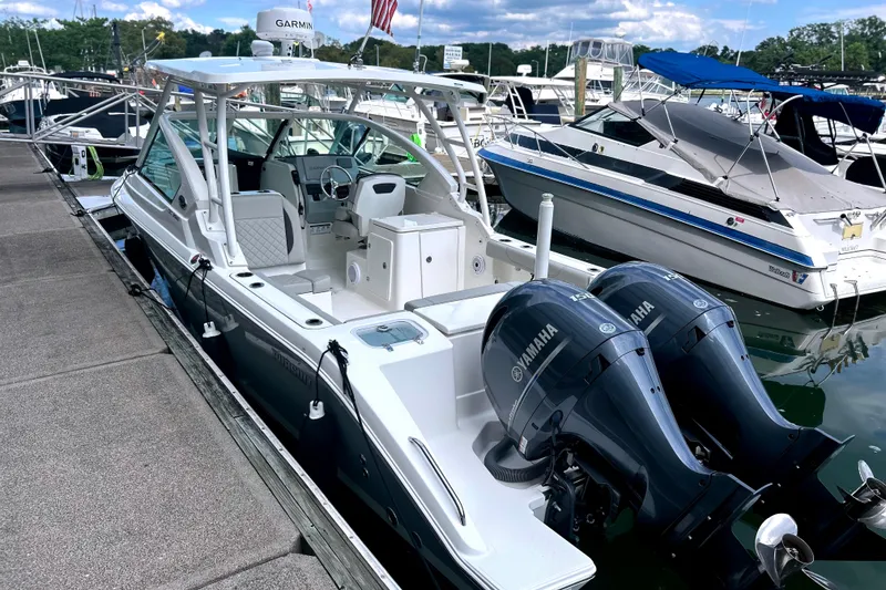 Slide: The Image of 2023 Pursuit DC 266 Dual Console boat docked with twin Yamaha engines. - 2