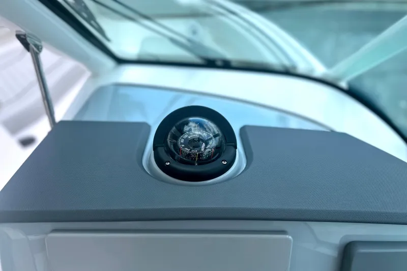 Slide: The Image of 2023 Pursuit DC 266 Dual Console boat compass on dashboard. - 24