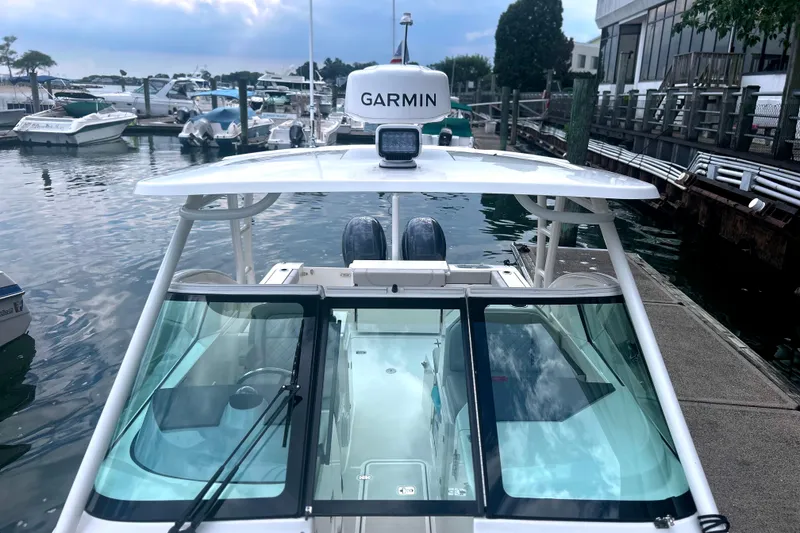 Slide: The Image of 2023 Pursuit DC 266 Dual Console boat docked at marina with Garmin equipment. - 25