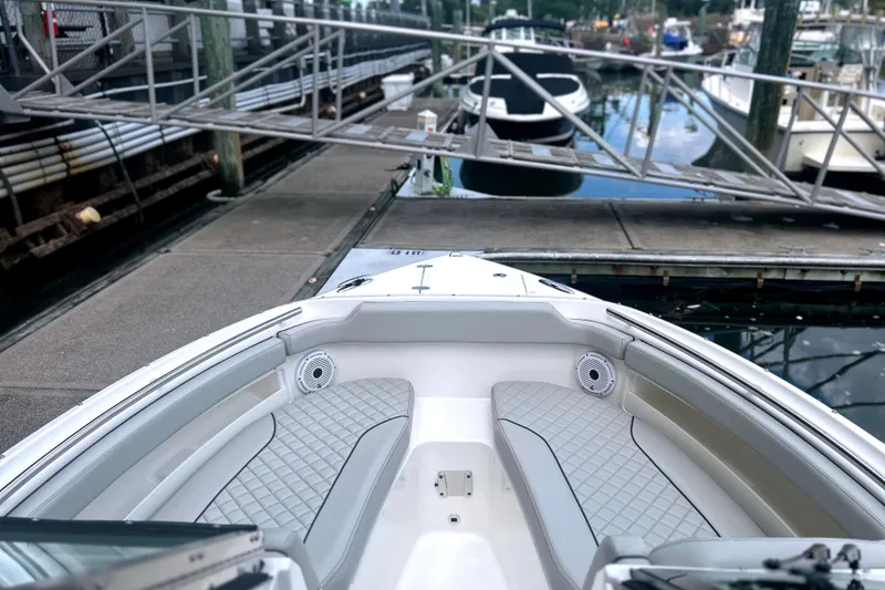 Slide: The Image of 2023 Pursuit DC 266 Dual Console boat docked at marina, featuring spacious seating. - 27