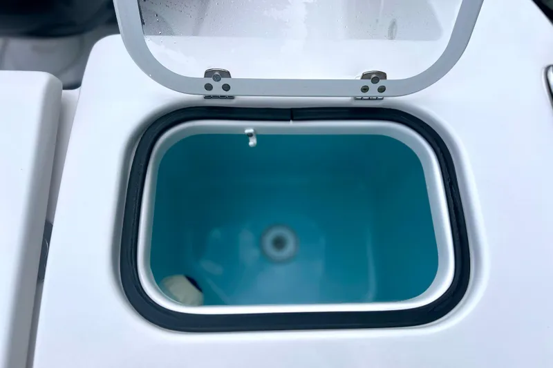 Slide: The Image of Open storage compartment on 2023 Pursuit DC 266 Dual Console boat. - 30