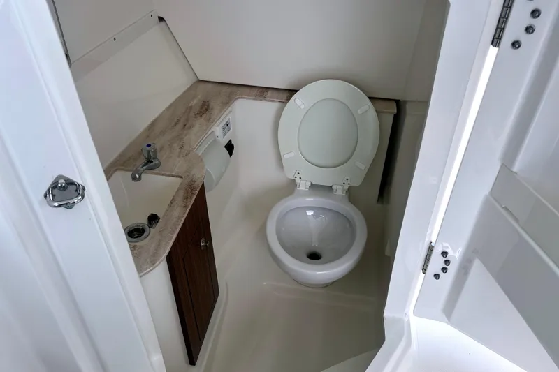 Slide: The Image of 2023 Pursuit DC 266 Dual Console boat bathroom with toilet and sink. - 35