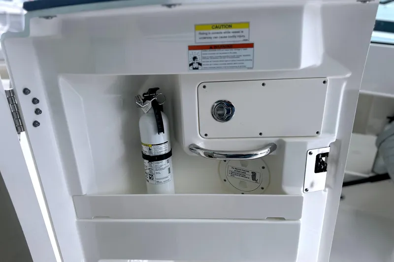 Slide: The Image of 2023 Pursuit DC 266 Dual Console boat storage with fire extinguisher. - 36
