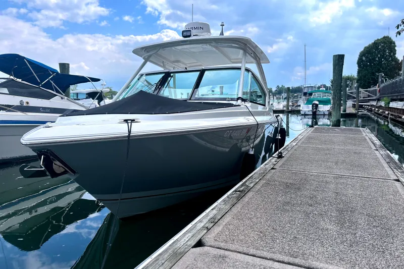 Slide: The Image of 2023 Pursuit DC 266 Dual Console boat docked at marina under cloudy sky. - 5