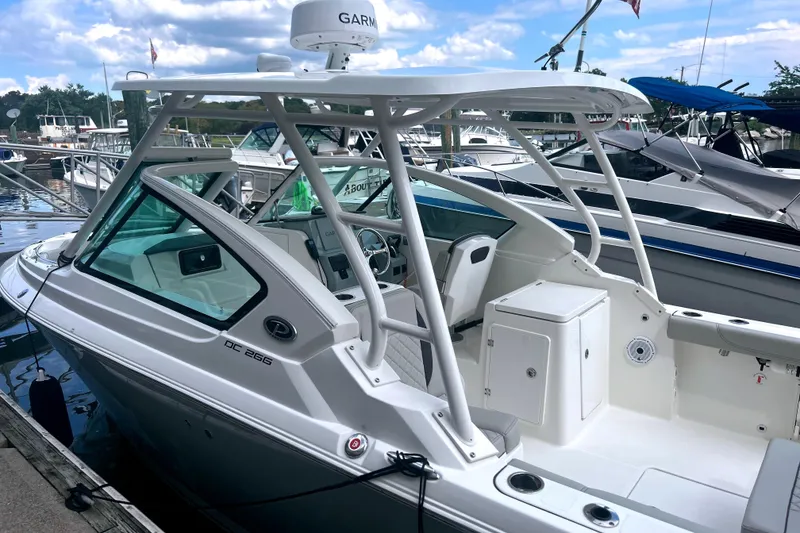 Slide: The Image of 2023 Pursuit DC 266 Dual Console boat docked at marina under blue sky. - 7