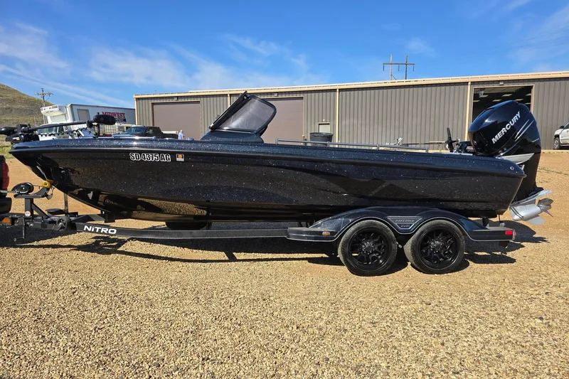 The Image of 2022 Nitro ZV21 Z-PRO boat on trailer, parked outdoors under clear blue sky. - 1