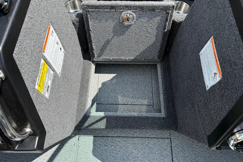Slide: The Image of Interior of 2026 Lund 1975 Tyee boat, featuring carpeted storage compartments and safety labels. - 18