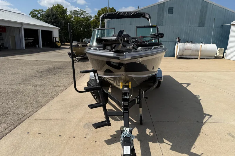 Slide: The Image of 2026 Lund 1975 Tyee boat on trailer, parked outside a warehouse. - 2