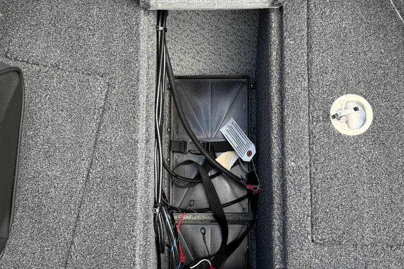 Slide: The Image of Battery compartment of 2026 Lund 1975 Tyee boat with wiring and carpeted interior. - 24