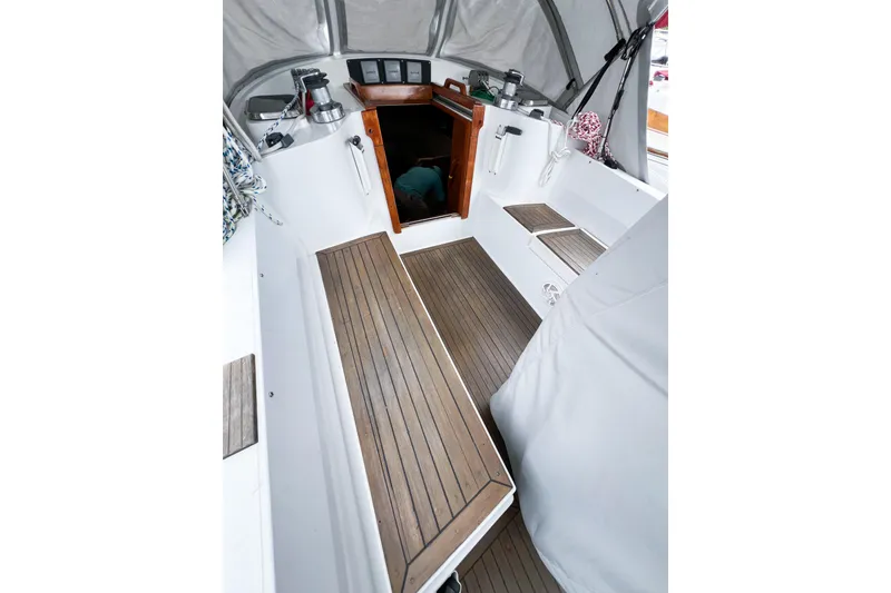 Slide: The Image of Cockpit of 1984 Trintella 42 sailboat with wooden flooring and open cabin entrance. - 12