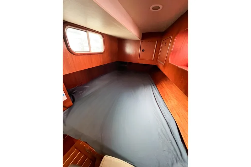 Slide: The Image of 1984 Trintella 42 yacht cabin with wooden interior and cozy bed. - 20