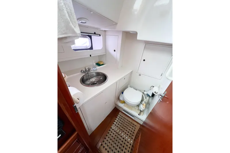 Slide: The Image of Compact bathroom in 1984 Trintella 42 yacht with sink, toilet, and window. - 32