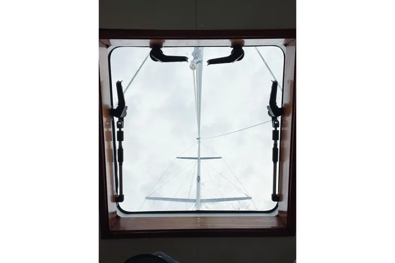 Slide: The Image of View through a Trintella 42 hatch, showcasing the mast against a cloudy sky. - 52