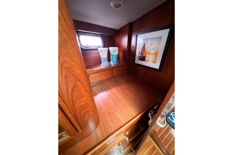 Slide: The Image of Wooden interior of 1984 Trintella 42 yacht with framed sailing photo and decorative items. - 53