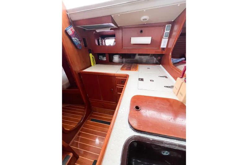 Slide: The Image of Interior of 1984 Trintella 42 sailboat with wooden cabinetry and compact kitchen area. - 57