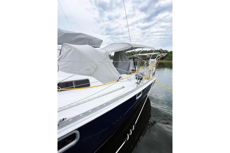 Slide: The Image of 1984 Trintella 42 sailboat docked, featuring covered deck and sleek design. - 6