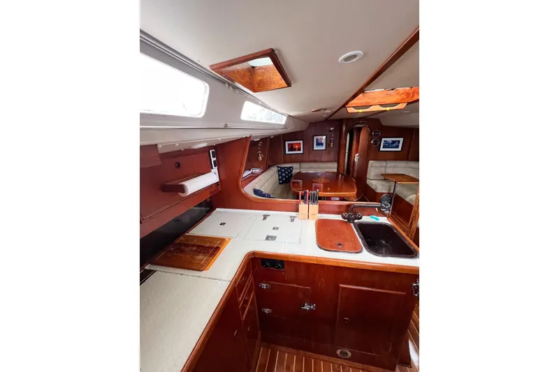 Slide: The Image of Interior of 1984 Trintella 42 yacht, featuring wooden cabinetry and cozy seating area. - 61