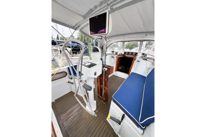 Slide: The Image of 1984 Trintella 42 yacht cockpit with steering wheel, navigation equipment, and blue seating. - 69