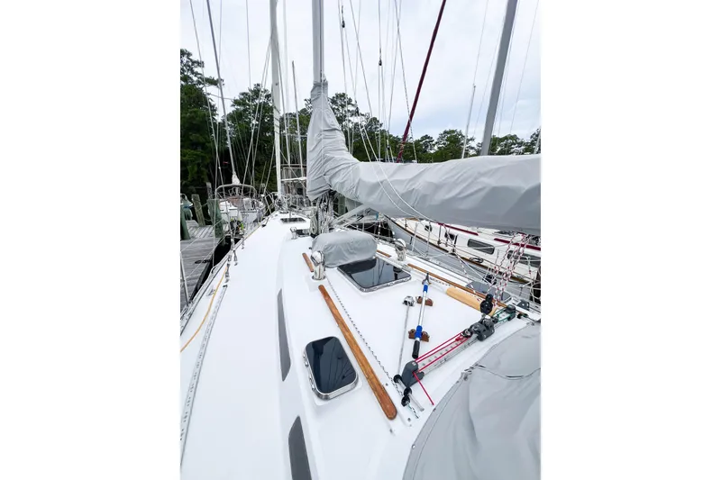 Slide: The Image of 1984 Trintella 42 sailboat deck with covered sails and rigging at a marina. - 7