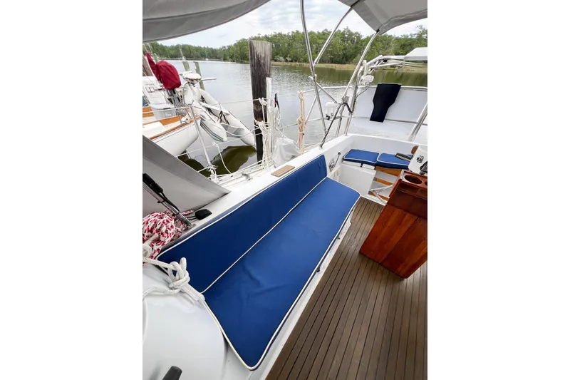 Slide: The Image of Cockpit of 1984 Trintella 42 sailboat with blue cushions and wooden flooring. - 73