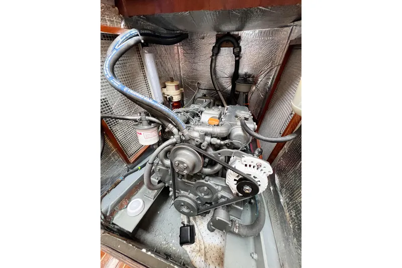 Slide: The Image of Engine compartment of a 1984 Trintella 42 sailboat, showcasing mechanical components and wiring. - 76