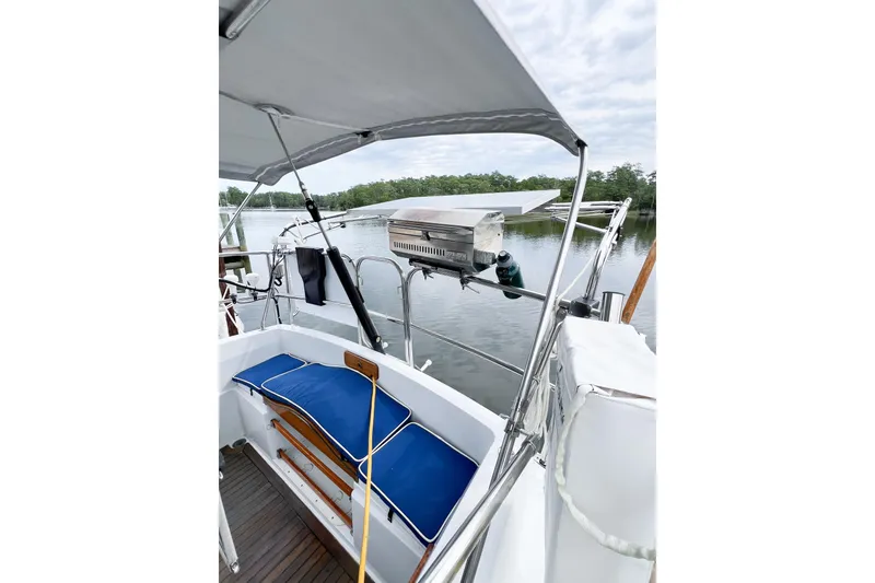 Slide: The Image of 1984 Trintella 42 sailboat cockpit with blue cushions, docked on a calm lake. - 80