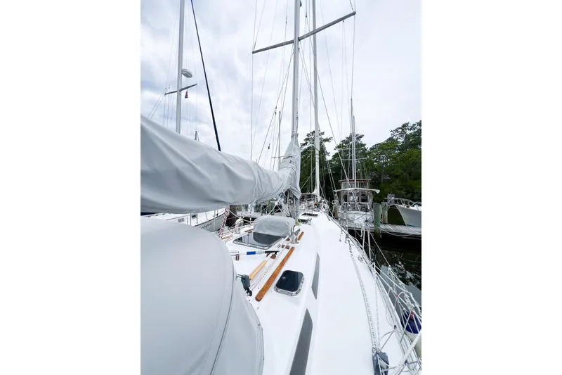 Slide: The Image of 1984 Trintella 42 sailboat docked, showcasing deck and mast in marina setting. - 9