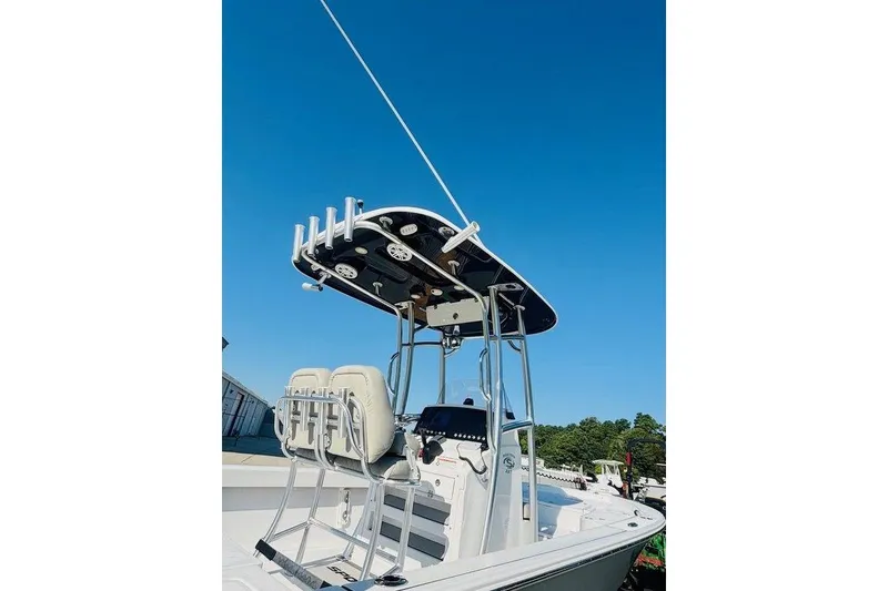 Slide: The Image of 2021 Sportsman Masters 227 Bay Boat with T-top and seating, under clear blue sky. - 4