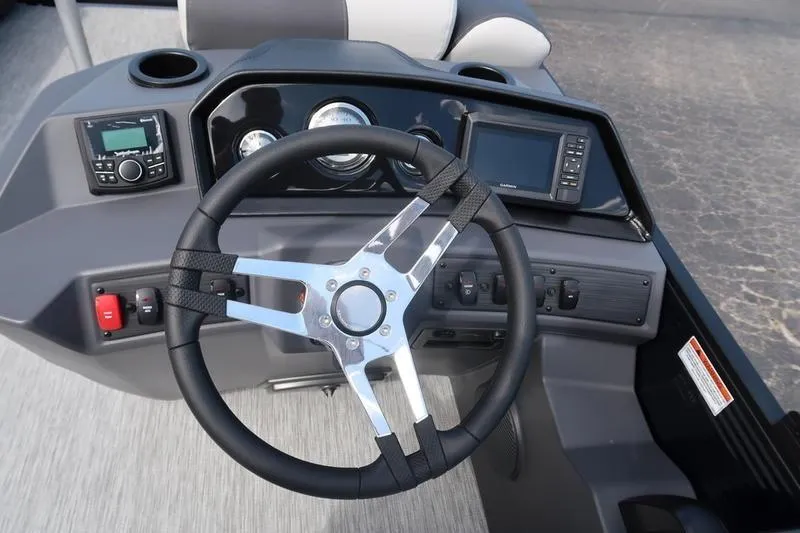 Slide: The Image of 2026 Bennington S Quad Bench 20 SSR boat dashboard with steering wheel and controls. - 15