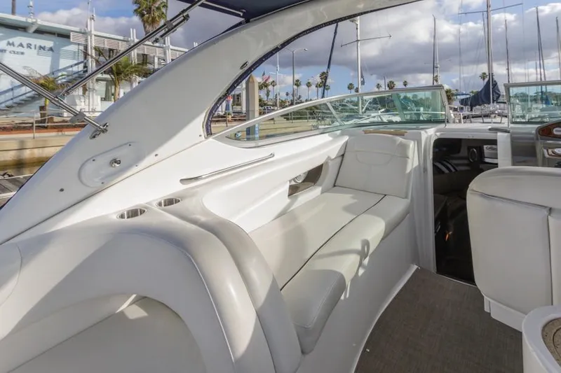 Slide: The Image of 2013 Rinker 290 Express Cruiser interior with white seating and marina view. - 10