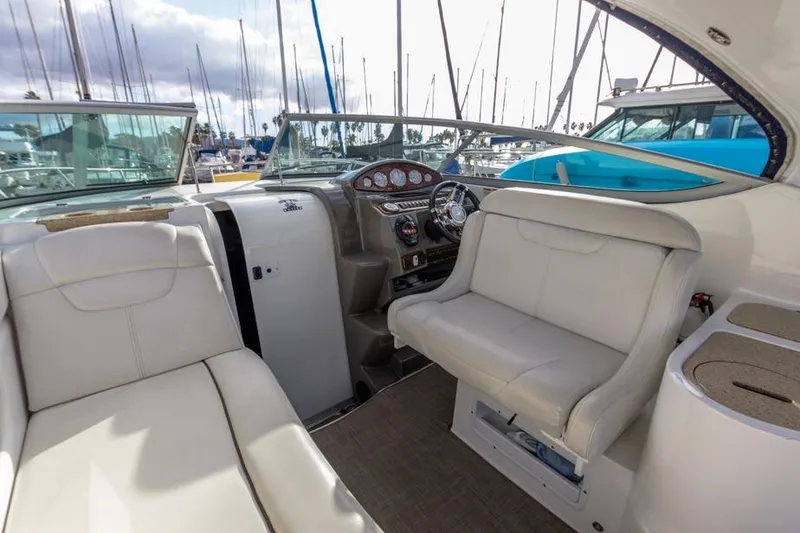 Slide: The Image of 2013 Rinker 290 Express Cruiser interior with helm, seating, and marina view. - 11