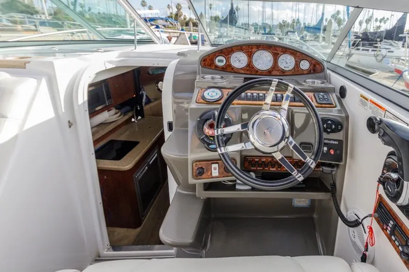 Slide: The Image of 2013 Rinker 290 Express Cruiser helm with steering wheel and control panel. - 12
