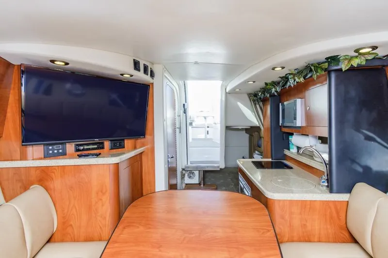 Slide: The Image of Interior of 2013 Rinker 290 Express Cruiser with TV, kitchenette, and seating area. - 15