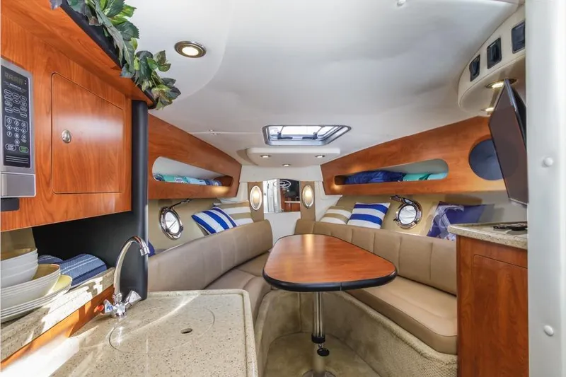 Slide: The Image of 2013 Rinker 290 Express Cruiser interior with cozy seating and modern amenities. - 17