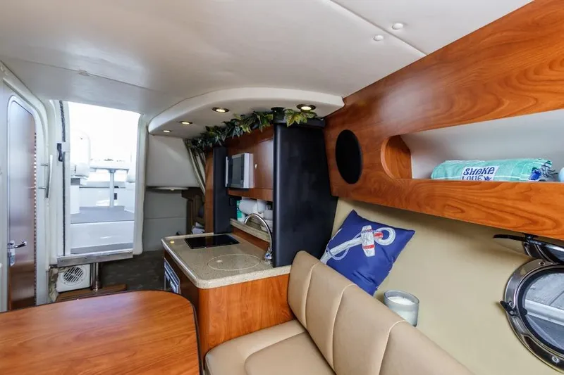Slide: The Image of 2013 Rinker 290 Express Cruiser interior with kitchenette and seating area. - 20