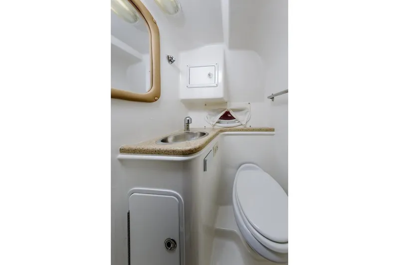 Slide: The Image of 2013 Rinker 290 Express Cruiser bathroom with sink, mirror, and toilet. - 21