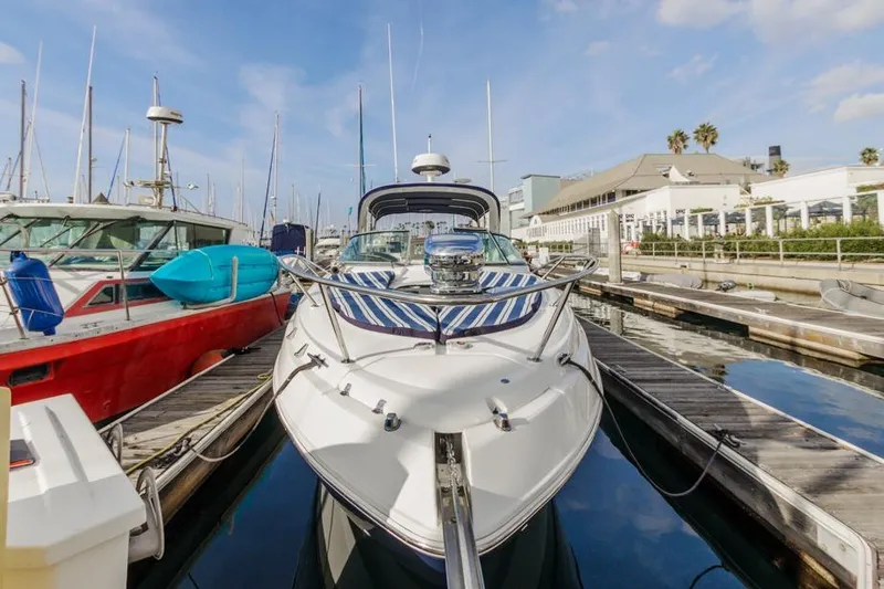 Slide: The Image of 2013 Rinker 290 Express Cruiser docked at marina, surrounded by other boats. - 3