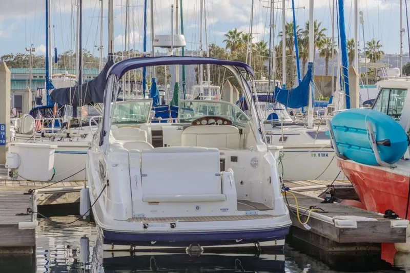 Slide: The Image of 2013 Rinker 290 Express Cruiser docked at a marina with sailboats. - 4