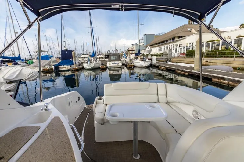 Slide: The Image of 2013 Rinker 290 Express Cruiser interior at marina with sailboats and waterfront buildings. - 6