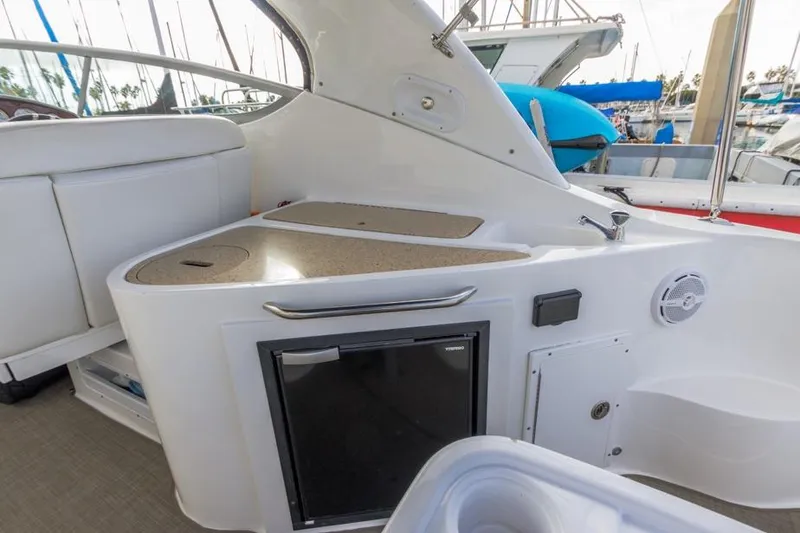 Slide: The Image of 2013 Rinker 290 Express Cruiser interior with kitchenette and seating area. - 8