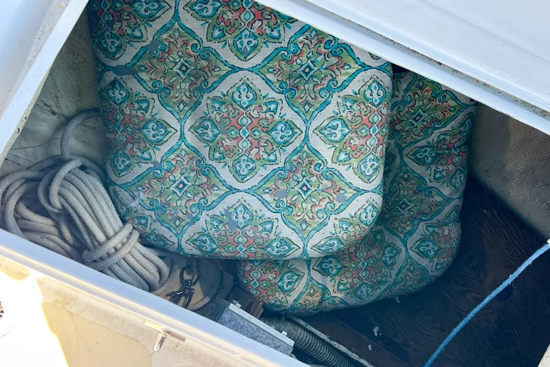 Slide: The Image of Storage compartment in 1978 CAL 34 boat with patterned cushions and coiled rope. - 14