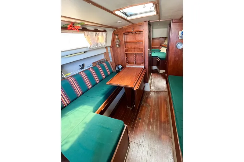 Slide: The Image of Interior of 1978 CAL 34 sailboat with wooden furnishings and green seating. - 20