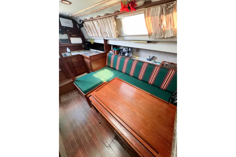 Slide: The Image of Interior of a 1978 CAL 34 sailboat with wooden furnishings and striped cushions. - 21