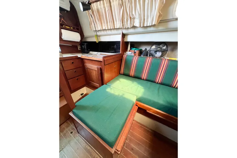 Slide: The Image of Interior of 1978 CAL 34 sailboat with green cushions and wooden cabinetry. - 22