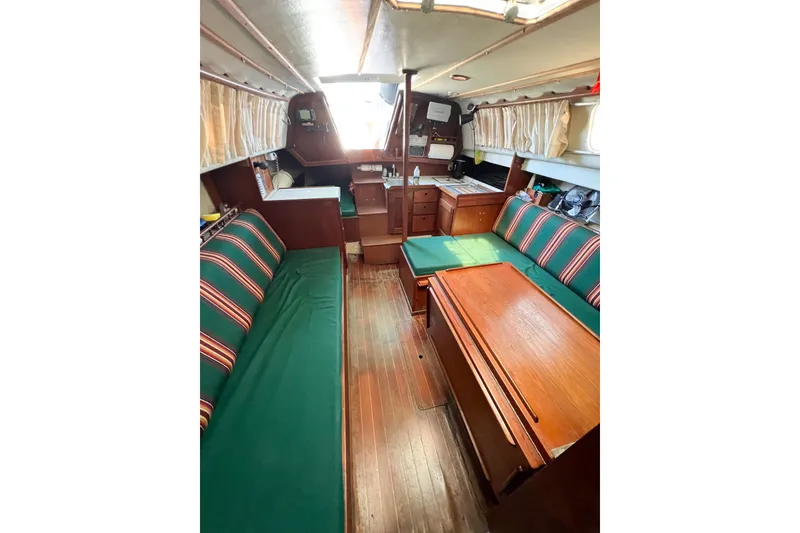 Slide: The Image of Interior of a 1978 CAL 34 sailboat with green-striped seating and wooden furnishings. - 24