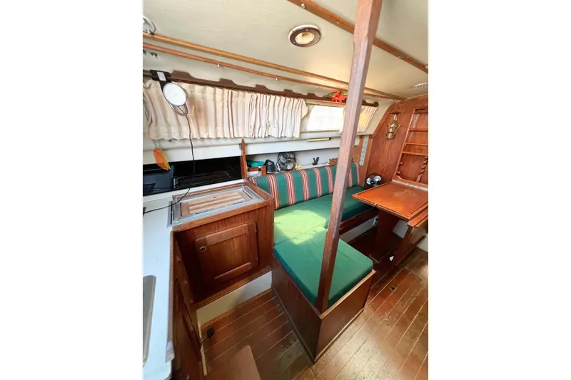 Slide: The Image of Interior of 1978 CAL 34 sailboat with wooden furnishings and green seating. - 26
