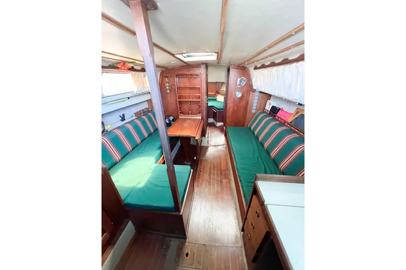 Slide: The Image of Interior of a 1978 CAL 34 sailboat with green-striped seating and wooden furnishings. - 27